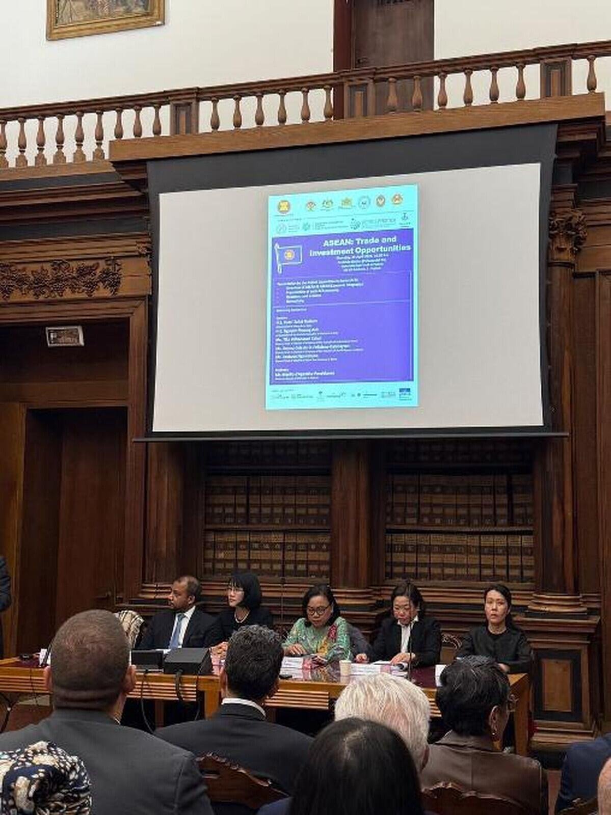 I rappresentanti diplomatici dei sette Paesi ASEAN al tavolo dei relatori sotto il poster ASEAN Trade and Investment Opportunities